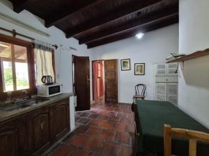 cocina con mesa y microondas en Casita de Campo El Tatata, en San Lorenzo