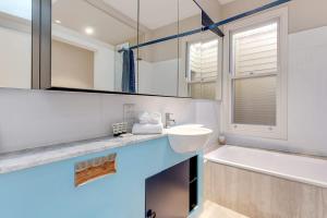 a bathroom with a sink and a tub and a mirror at 2 mins walking to harbour bridge in Sydney