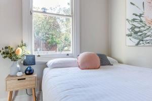 a bedroom with a bed with a pink pillow on it at 2 mins walking to harbour bridge in Sydney