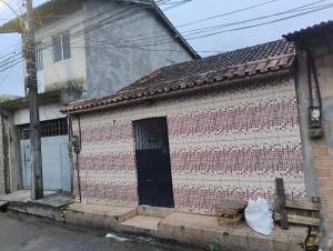 una piccola casa di mattoni con una porta nera di Paracasa ad Ananindeua