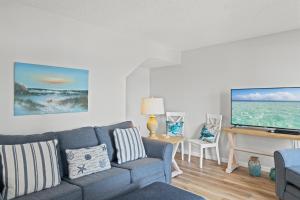 un salon avec un canapé et une télévision à écran plat dans l'établissement Pinnacle Port A-701, à Carillon Beach