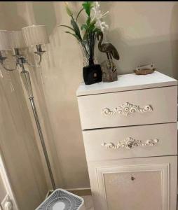 eine weiße Kommode mit einer Pflanze drauf in der Unterkunft Relax Home in Kairo