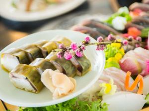 einen Teller mit Sushi und Gemüse auf dem Tisch in der Unterkunft Umibe no Kajuen - Vacation STAY 17476v in Konan