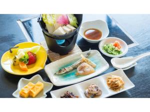 ein Tisch mit Tellern voller Essen und einer Schüssel Salat in der Unterkunft Umibe no Kajuen - Vacation STAY 17476v in Konan