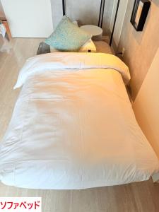 1 cama blanca grande en una habitación en Plus Life Shiraho A号室, en Ishigaki Island