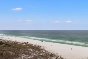 a beach with a group of people in the ocean at Pinnacle Port, A-708 in Carillon Beach