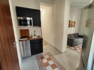a small kitchen with a sink and a microwave at Palazzo Orangea 1 piano in Bagheria