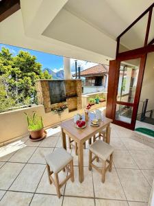 a patio with a table and chairs and a fireplace at Duplex incrível a 5 min do centro com piscina in Nova Friburgo