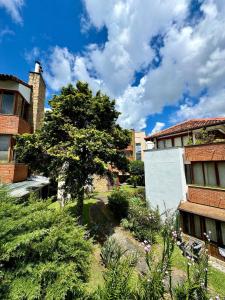 a tree in a yard next to a building at Duplex incrível a 5 min do centro com piscina in Nova Friburgo