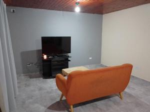 a living room with a couch and a flat screen tv at Casa Nómade in Perito Moreno