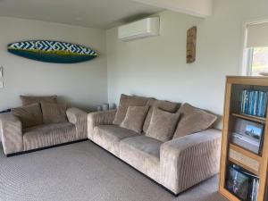 a living room with a couch and a tv at RAGLAN - FULLY self contained 1 bedroom in Raglan