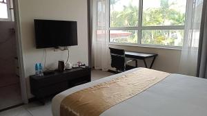 阿皮亚Tauese Seaview Hotel的一间带床和平板电视的卧室