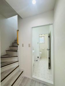 ein weißes Bad mit einer Treppe und einem WC in der Unterkunft LOFT-Hatsudai hostel初台SY0362 in Tokio