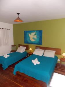 Un dormitorio con dos camas con toallas encima. en Hotel Salvador, en Poços de Caldas