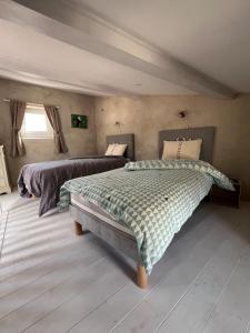 a bedroom with two beds and a window at La bâtisse de Coustouge in Coustouge