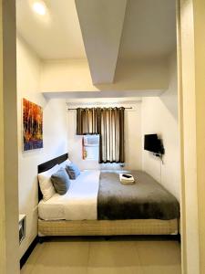 a bedroom with a bed and a window at BGC Suites Uptown in Makati