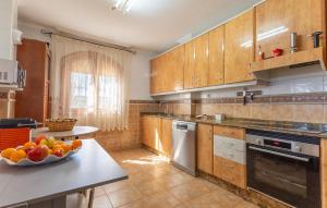 eine Küche mit Holzschränken und einer Schale mit Obst auf dem Tisch in der Unterkunft Awesome Home In Cartagena With Wifi in Cartagena