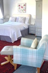 a bedroom with a bed and a chair and a couch at Glenburn, Peaceful Accommodation Fochabers in Fochabers