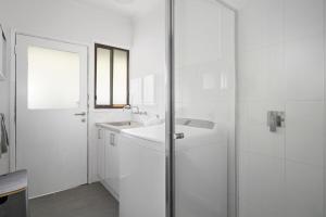 a white bathroom with a sink and a shower at Balnarring Beach Haven - peaceful retreat, walk to beach in Balnarring Beach +13 photos