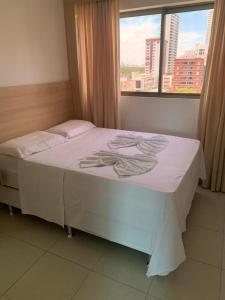 un letto bianco in una stanza con una finestra di Beach Class Convention HOM a Recife Altre 12 foto