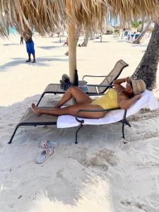 a woman laying on a beach chair on the beach at Madonna Pool Beach los Corales in Punta Cana