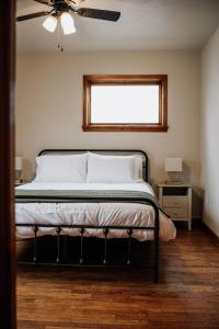 a bedroom with a bed with a ceiling fan and a window at The Mueller Haus in Hermann