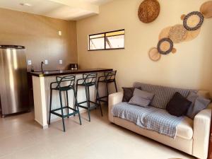 a living room with a couch and a kitchen with a bar at Sorte e Amaro in Santo Amaro