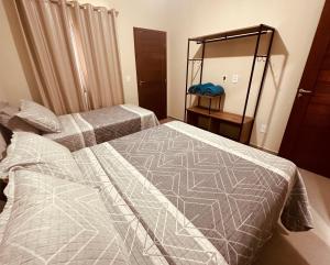 a bedroom with two beds and a mirror at Sorte e Amaro in Santo Amaro
