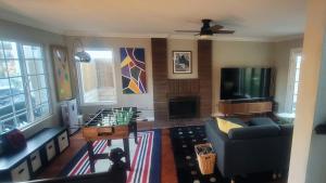 a living room with a couch and a tv at Coastal Retreat Home 2 miles from Beach in Huntington Beach