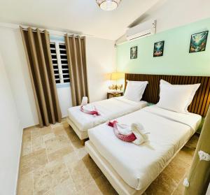 - deux lits dans une chambre d'hôtel avec des animaux rembourrés dans l'établissement Villa Yaya, à Le Robert 39 autres photos