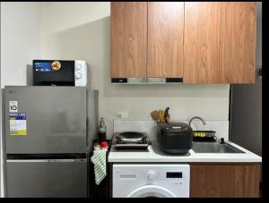 a kitchen with a sink and a stove and a refrigerator at Be Housed Studio Bldg 302 in Lapu Lapu City +2 photos
