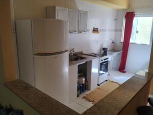 eine Küche mit einem weißen Kühlschrank und einer Spüle in der Unterkunft Apartamento completo na praia in Mangaratiba + 7 Fotos