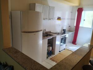 eine Küche mit einem weißen Kühlschrank und einer Spüle in der Unterkunft Apartamento completo na praia in Mangaratiba