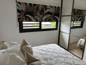 una camera con un letto e un grande specchio di Arbre a pain Beach Lodge a Punaauia