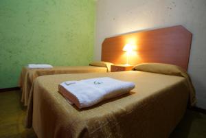 two beds in a hotel room with a towel on them at Hotel Parada in Buenos Aires