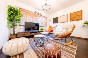 a living room with a couch and chairs and a television at 真 Private accommodation with sauna, close to USJ and Expo Park, free parking, 4 bedrooms, 8 beds, 2 bathrooms in Osaka