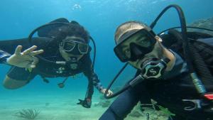 two people are scuba diving in the water at La Posada del Buzo in Colón