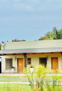 una casa con porte in legno e piante di fronte ad essa di Pueblo Viejo La Palmira a Isla Itá Pyntá