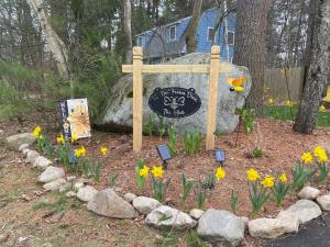 a sign in front of a garden with flowers at The Hive - Unique Themed Getaway in Billerica