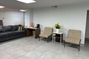 a waiting room with a couch and two chairs at Suburban Studios Fairborn - Dayton in Fairborn