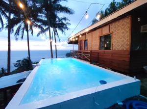 曼巴豪Raiah's Viewhouse的一座位于大海房子前面的游泳池