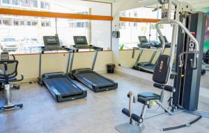 a gym with several treadmills and exercise bikes at Loft Mana Experience INN in Ipojuca