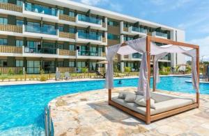 a hotel pool with a gazebo in front of a building at Loft Mana Experience INN in Ipojuca +4 photos