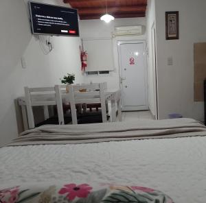 a bedroom with a bed and a table and a tv at Los Colibríes in San José