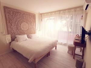 a bedroom with a white bed and a window at Hotel Tennis International in Cap d'Agde
