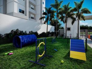 a playground with play equipment in the grass at Apartamento de 2 quartos - 900m da Praia! in Cabedelo