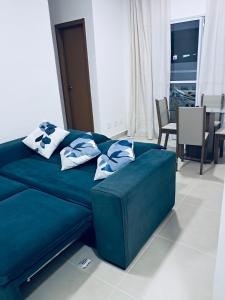 a blue couch with pillows on it in a living room at Apartamento de 2 quartos - 900m da Praia! in Cabedelo +29 photos