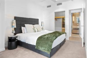a bedroom with a large bed with a green blanket at Queens Wharf - Brisbane CBD Luxury with pool and gym in Brisbane