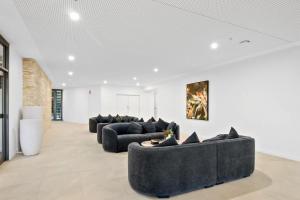 a living room with two black couches in a room at Queens Wharf - Brisbane CBD Luxury with pool and gym in Brisbane +4 photos
