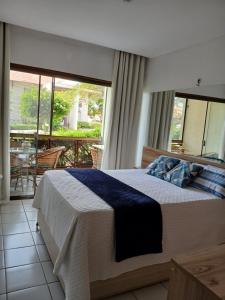 a bedroom with a large bed and a balcony at Flat Monte Castelo - Gravatá - Até 5 pessoas, próximo da área de lazer in Sairé +51 photos